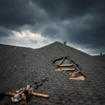 Roof showing storm damage with missing shingles and exposed wood, debris scattered, under dark cloudy skies, highlighting urgent need for emergency roof repair in Millersville, MD.